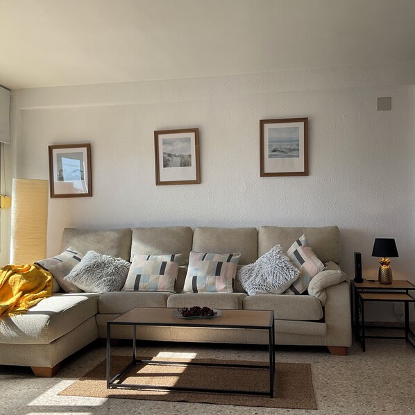 A living room with a sofa, coffee table, and framed pictures on the wall. - Casa Angel Malaga (Málaga)