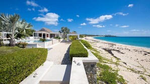 Una proprietà sul lungomare con vista diretta sull'oceano, un vialetto che conduce a un gazebo e una zona piscina.