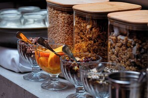 A variety of food containers with different contents, including grains and dried fruits, on a shelf. - Sun Street Hotel Shoreditch (London)