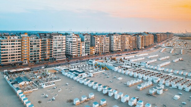 Un complejo residencial de edificios altos con varias torres de apartamentos, un estacionamiento y vista al agua.