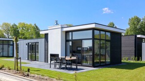 Una casa moderna y compacta con un patio que tiene una mesa y sillas.
