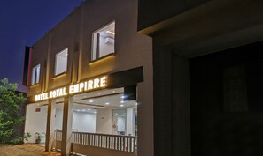 A hotel exterior with a sign reading "HOTEL ROYAL EMPIRE" and a visible entrance.