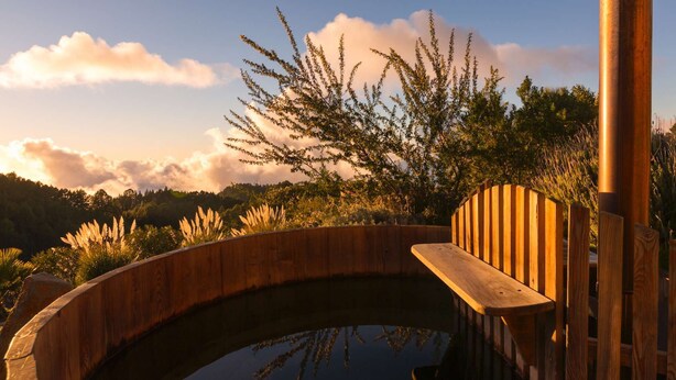 A wooden deck with a bench overlooking a circular pool, surrounded by lush vegetation and trees. - Absolute Ruhe und Alleinlage Über den Wolken, Pool - Panorama Suite El Mirador (Las Tricias)