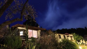 A rustic stone building with a large tree in the foreground, under a starry night sky. - Absolute Ruhe und Alleinlage Über den Wolken, Pool - Panorama Suite El Mirador (Las Tricias)