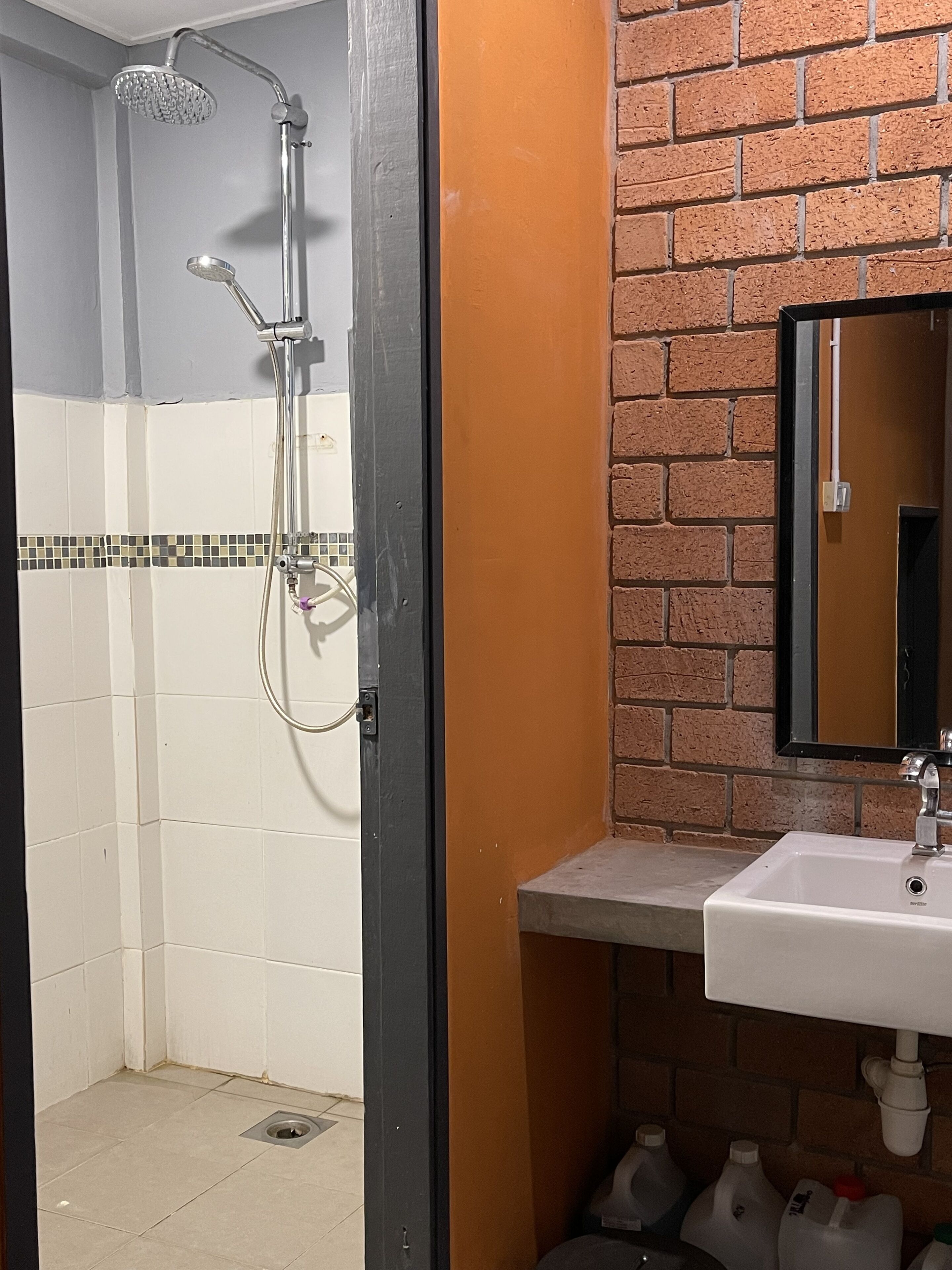 Un baño con ducha, lavabo y espejo.