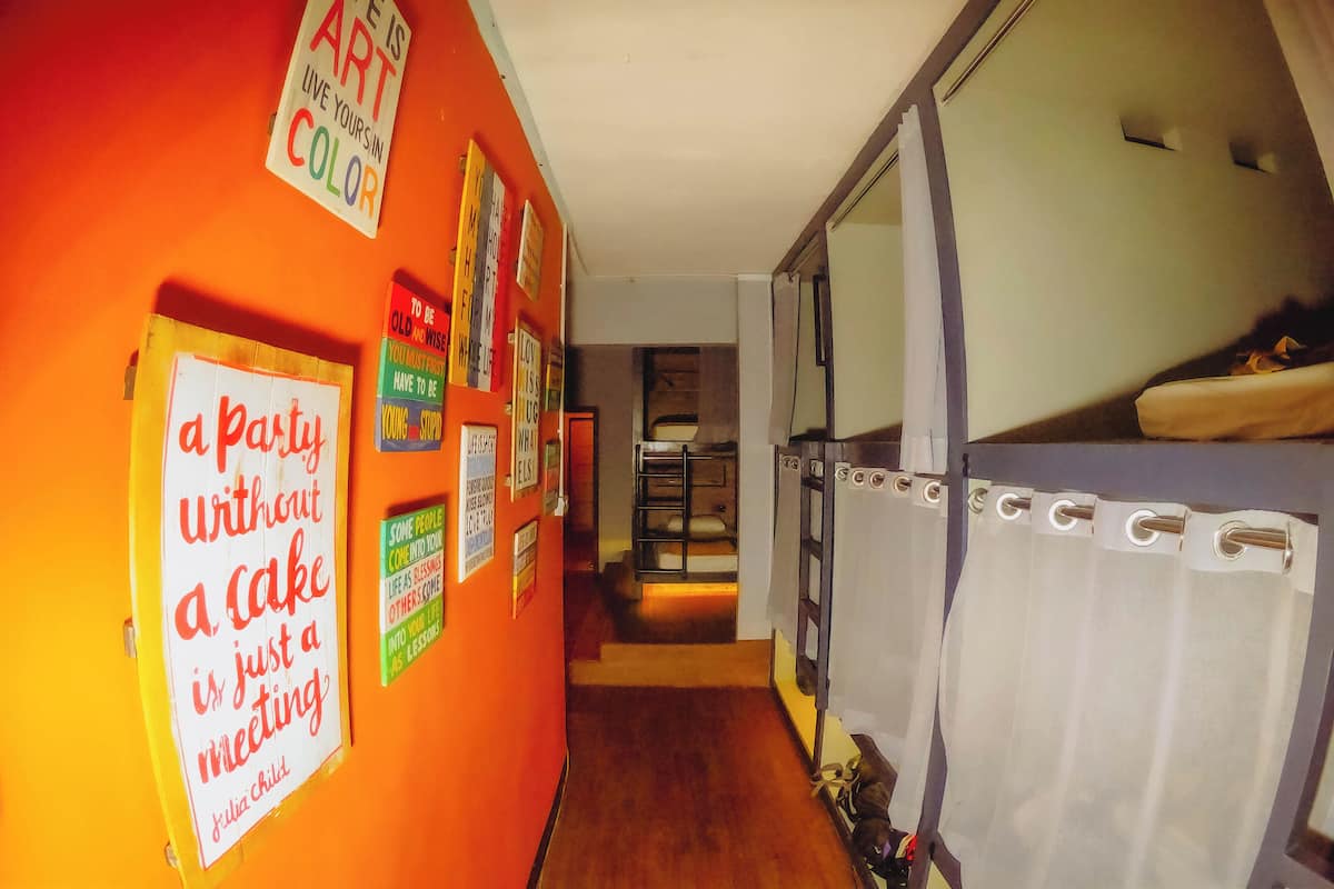 A hallway with orange walls, a bunk bed, and various motivational posters.