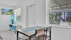Un comedor con una mesa, sillas, un armario azul y una puerta.