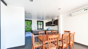 Una cocina moderna con armarios oscuros, estufa integrada y ventana con vistas a la vegetación.