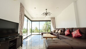 Una sala de estar moderna con televisor de pantalla plana, sofá de cuero y una mesa de centro de madera.