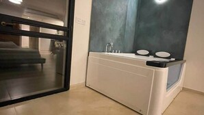 A modern bathroom with a large mirror, a white sink, and a glass shower enclosure. - Tavor View Suites (Galil Tachton)