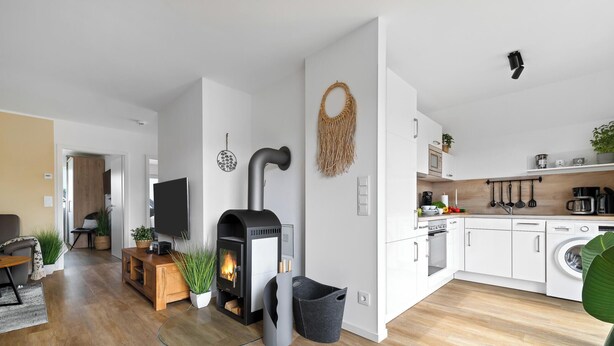 Un salon moderne avec une cheminée, un téléviseur et un coin repas.