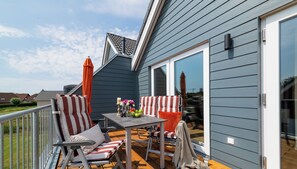 Une terrasse dotée de mobilier d’extérieur, d’une table et d’une chaise.