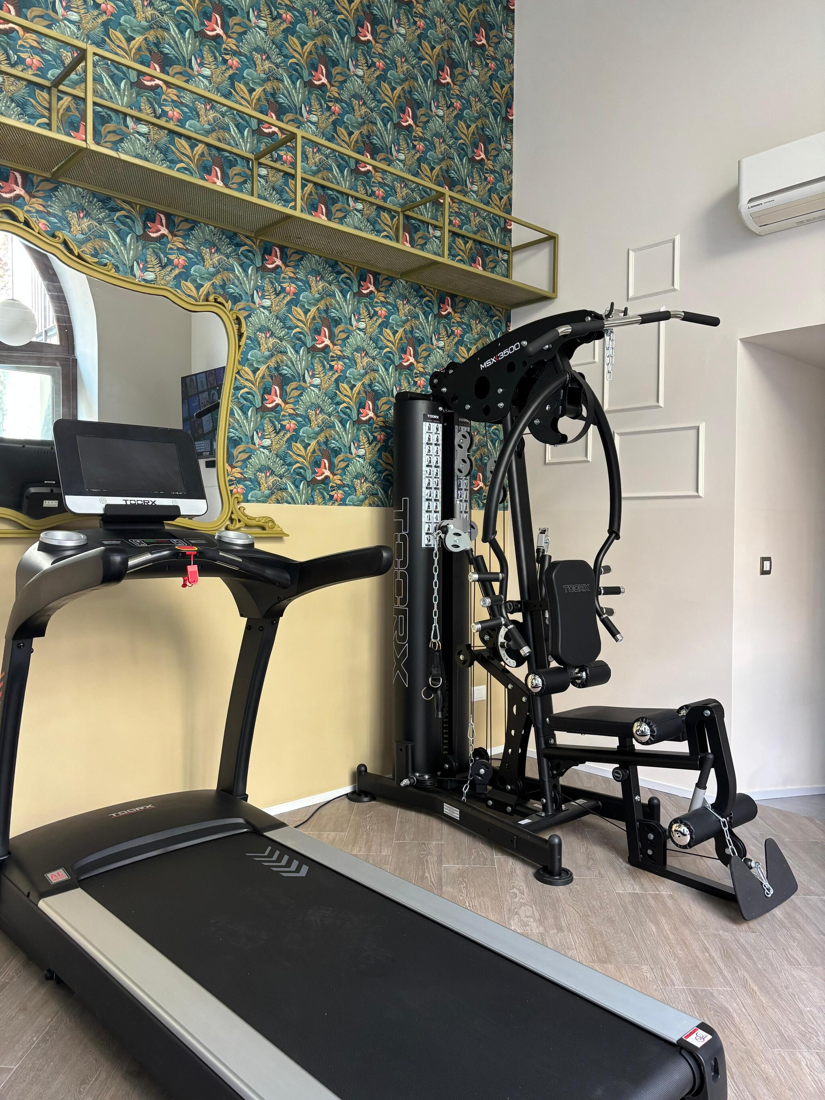A home gym with a treadmill, a stationary bike, and a weight machine.