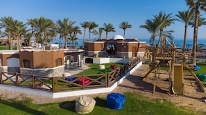Un resort con piscina, palmeras y vista al mar.