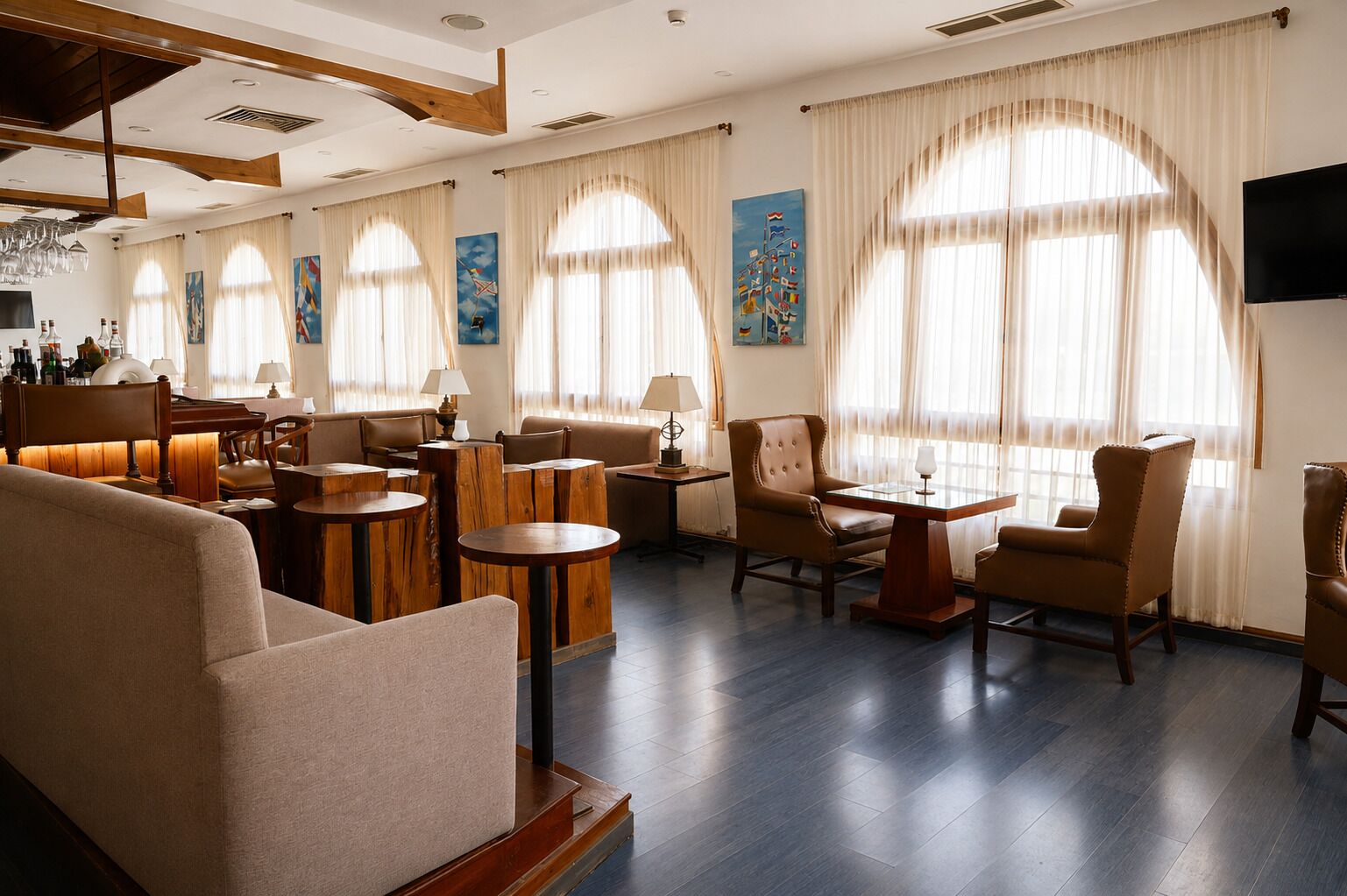 Un vaste espace de détente doté de nombreux sièges, notamment des canapés et des fauteuils, disposés autour d’une table centrale.