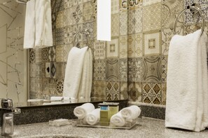 A bathroom with patterned tiles, a sink, and towels. - Safir Dahab Resort (Dahab)