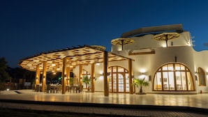 Un edificio con zona de estar al aire libre techada y una amplia entrada de arco.