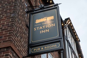 A sign for The Station Inn, indicating it offers pub and rooms.