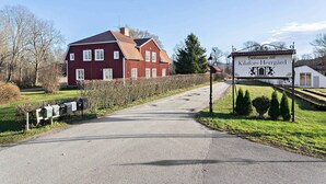 A red building with a sign reading "Klafors Herrgård".
