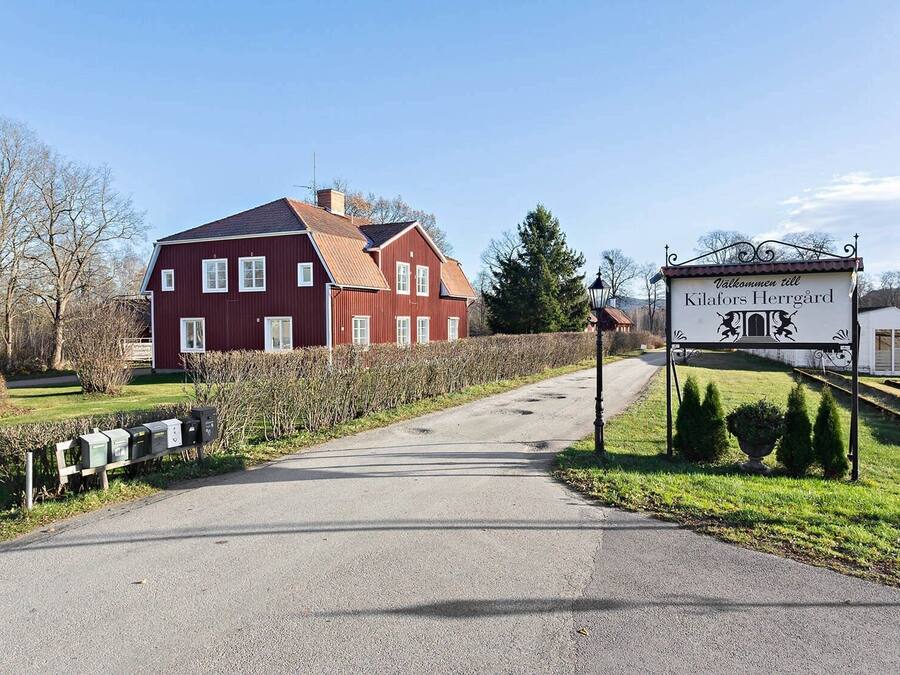 A red building with a sign reading "Klafors Herrgård".