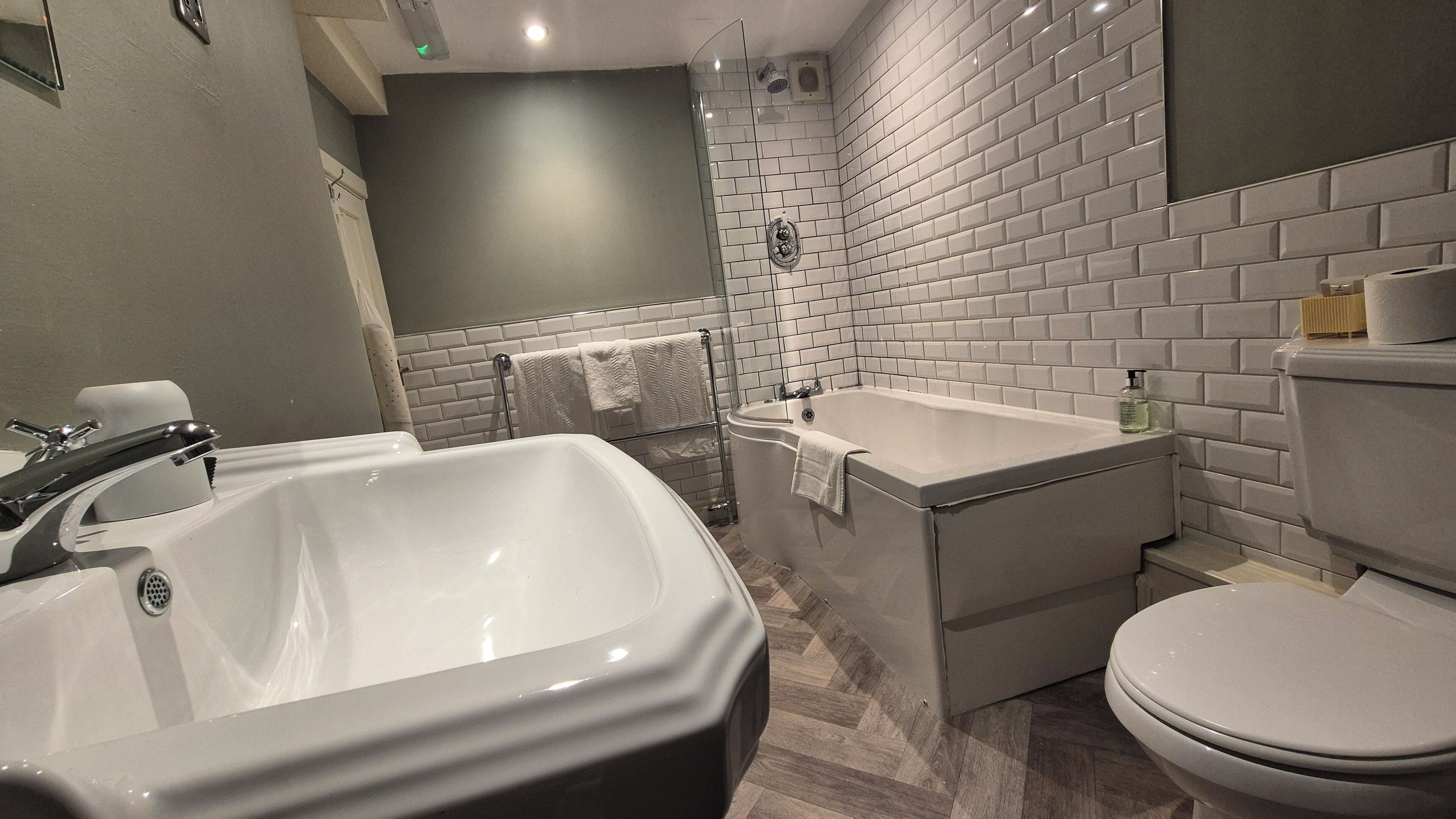 A modern bathroom with a large bathtub, a separate shower area, and a toilet.