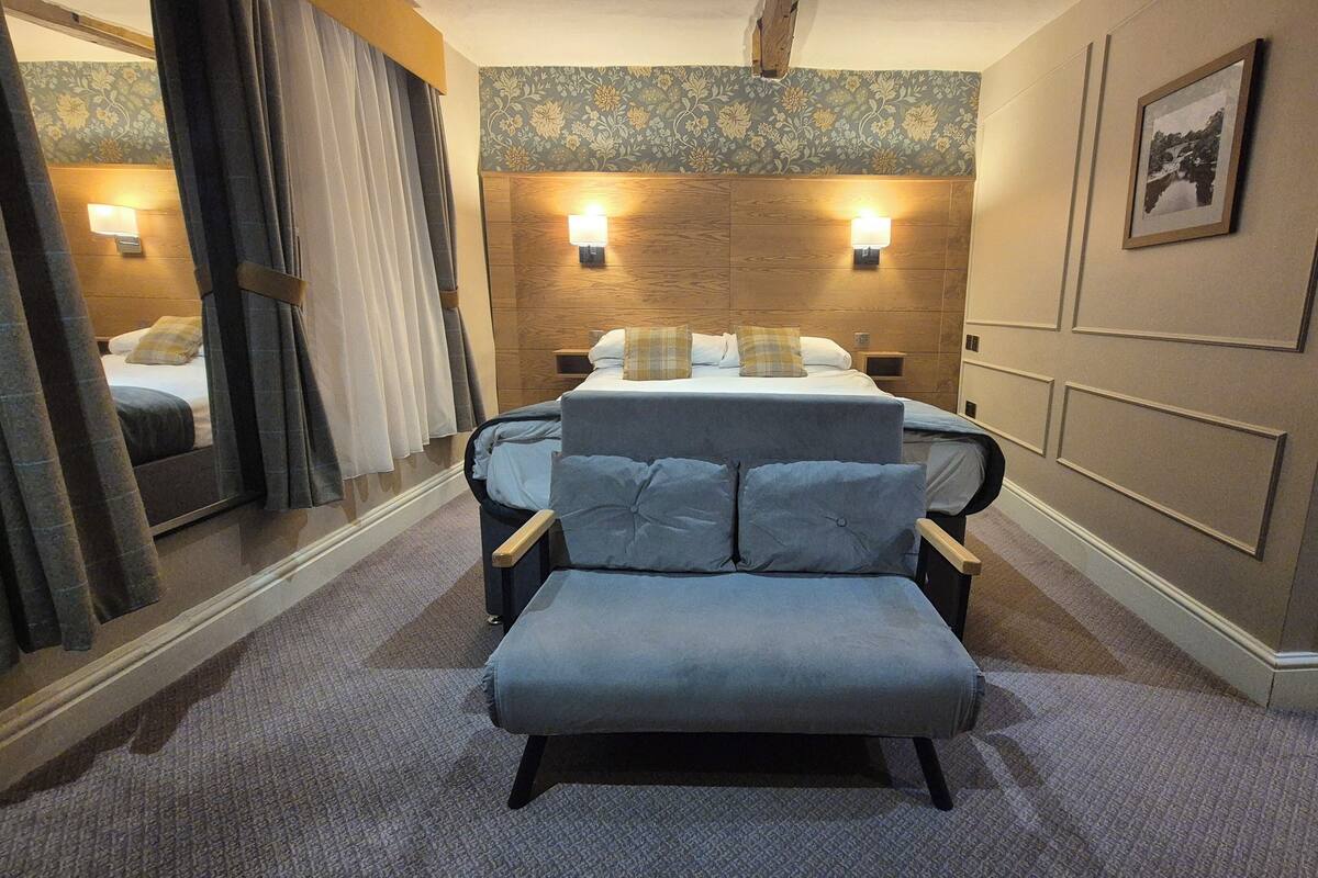 Ein Hotelzimmer mit einem großen Bett, einer Sitzecke und einem Spiegel.