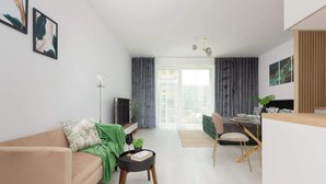 Een moderne woonkamer met een bank, een salontafel en een eethoek met een stoel en tafel.