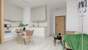 Een modern appartement met keuken, eethoek en woonkamer.