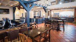 A restaurant with a bar area, seating arrangements, and a staircase. - The Oak (Coventry)