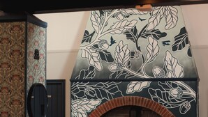 A cozy room with a fireplace, patterned wallpaper, and comfortable seating. - The Oak (Coventry)