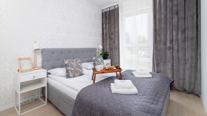 Ein ordentlich eingerichtetes Schlafzimmer mit Bett, Nachttisch und einem Tablett mit Frühstücksgebäck.