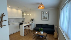 Un espace de vie moderne comprenant une cuisine, un coin repas, un canapé et une table basse.