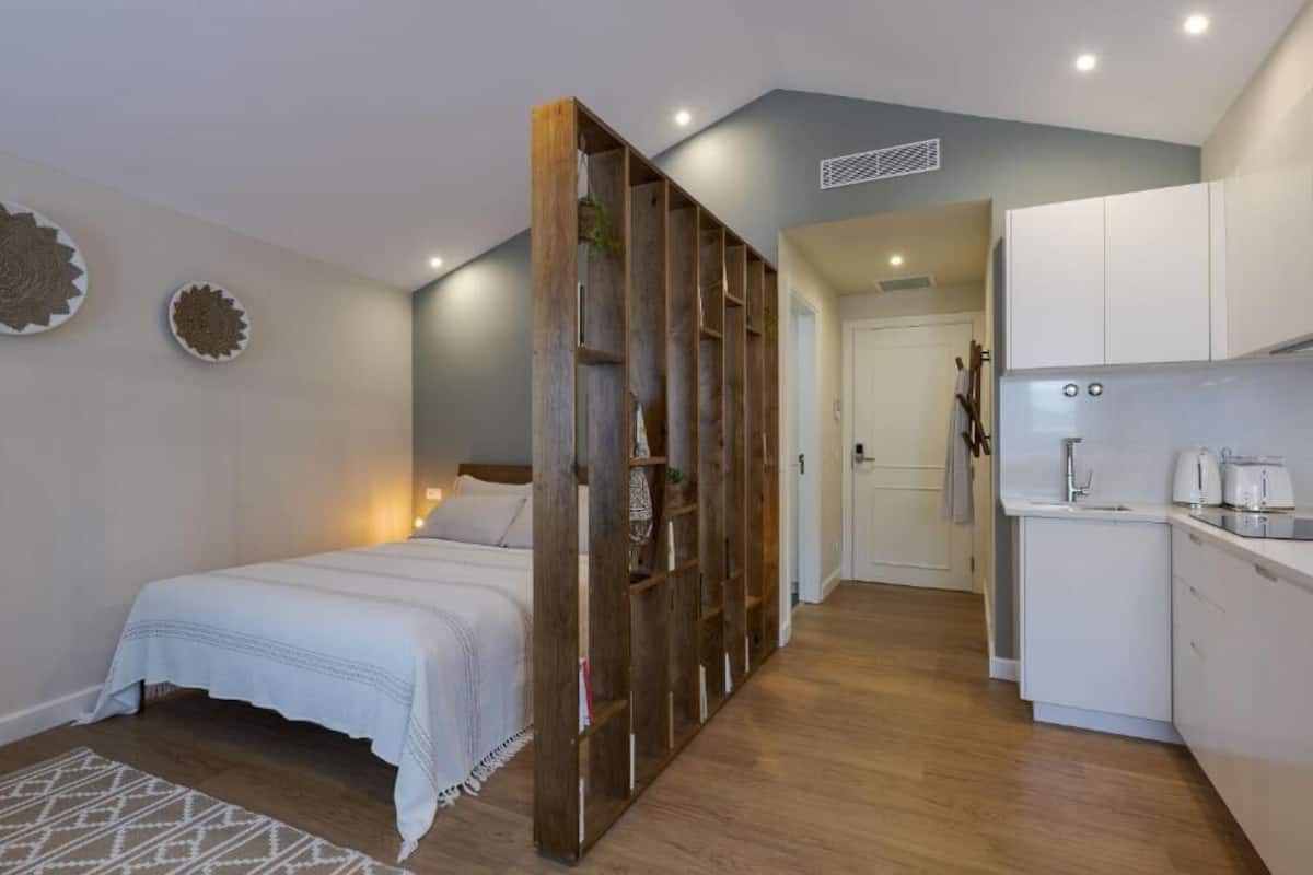 Une chambre à coucher de taille modeste, avec un lit et une armoire en bois.