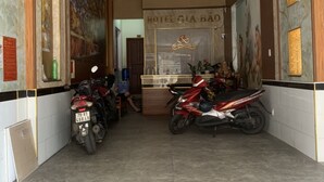 A hallway with two motorcycles parked, a reception desk, and a sign reading "HOTEL GIA BÁO". - Gia Bao Hotel (Ho Chi Minh City)