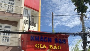 A building with a red facade and a sign that reads "KHÁCH SỬN GIA BẢO". - Gia Bao Hotel (Ho Chi Minh City)