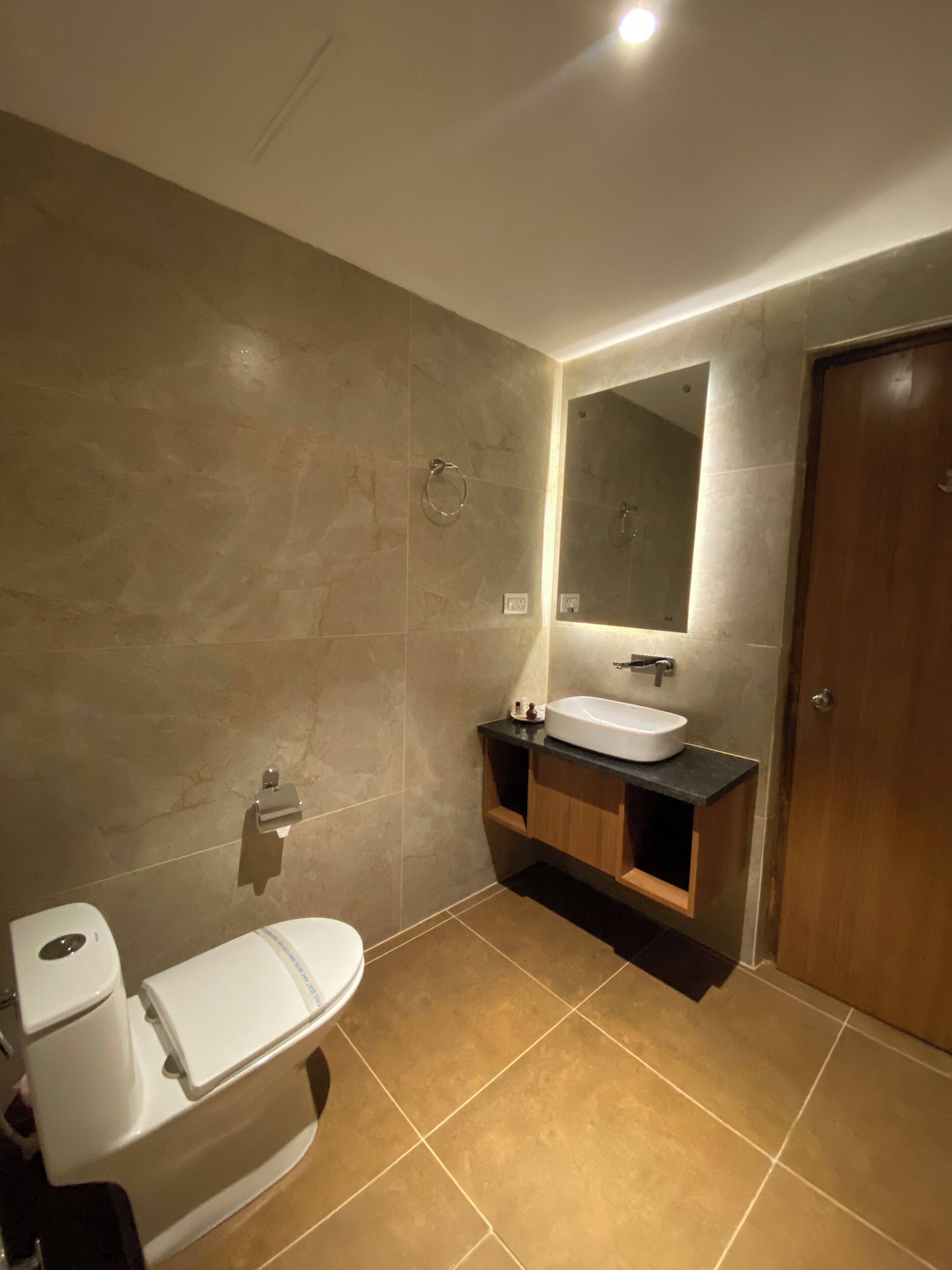 Un baño con inodoro, lavamanos y espejo.