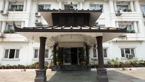 Entrada de hotel com projeto arquitetônico tradicional, apresentando uma galeria coberta e colunas.