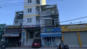 A multi-story building with a hotel named 'Tuong Phat' on the ground floor, a 'Min Vu 1' store on the second floor, and 'Lan Lan' on the third floor. - Italy Hotel (Nam Nha Trang)