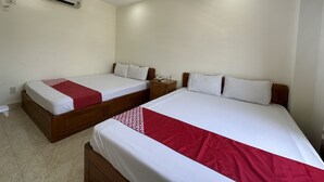 A hotel room with two beds, each with white bedding and red accents, a wooden headboard, a nightstand with a phone, and an air conditioning unit on the wall. - Italy Hotel (Nam Nha Trang)