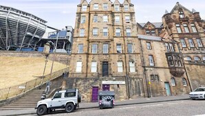 Un edificio histórico con una entrada destacada, una tienda de regalos y una estructura moderna cerca.
