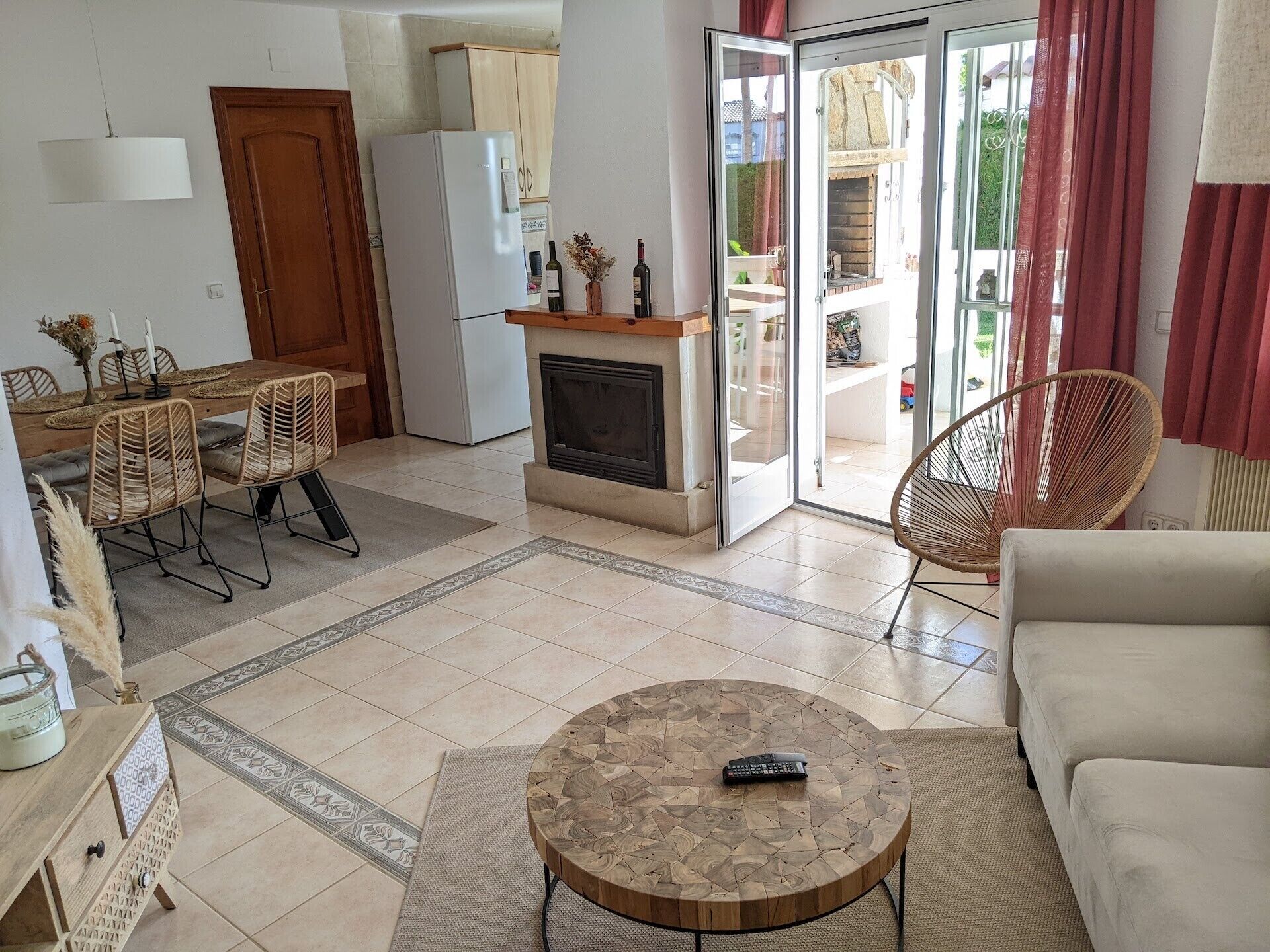 A living room with a fireplace, a dining area with a table and chairs, a sofa, and a round coffee table.