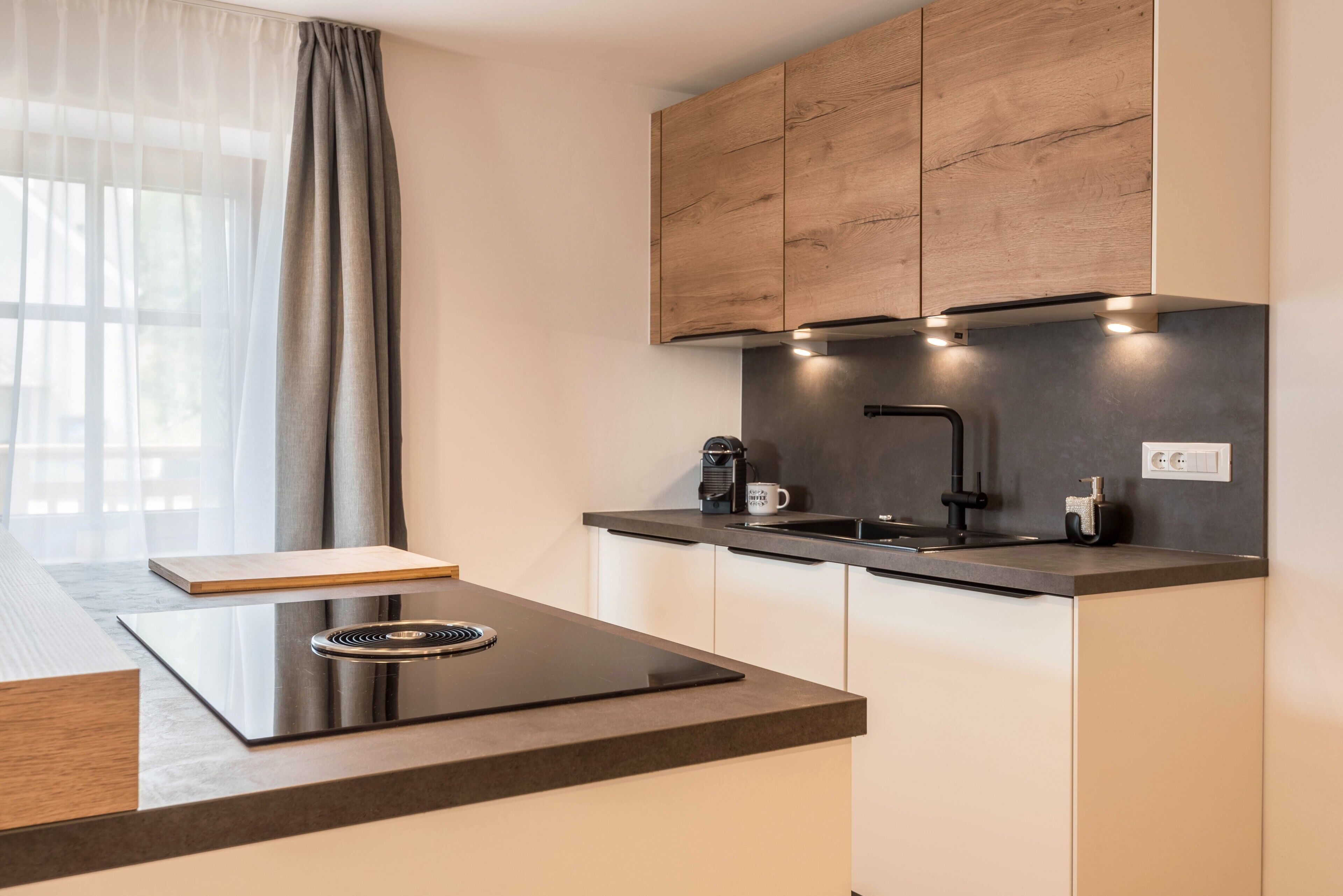 Una cocina moderna con estufa integrada, cafetera y lavaplatos.