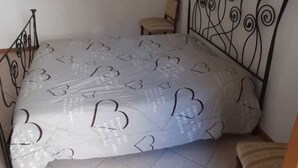 Une chambre à coucher avec un lit, une chaise et une petite table.