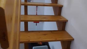 Eine Holztreppe mit Handlauf, die zu einer Empore führt.