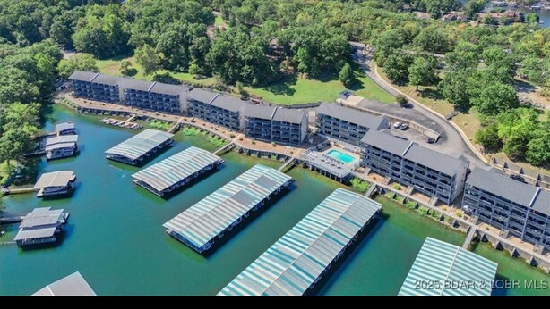 A resort with multiple buildings, a marina with boats, and a large pool. - Top floor, one bedroom condo on the lake! 
 Perfect for a couples weekend. (Osage Beach)