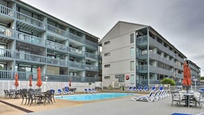 A hotel with a pool area, outdoor seating, and multiple balconies. - Top floor, one bedroom condo on the lake! 
 Perfect for a couples weekend. (Osage Beach)