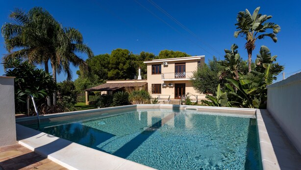 Une piscine à l’eau d’un bleu limpide, entourée d’une terrasse carrelée.