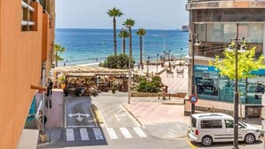 A coastal street with a view of the sea, a pedestrian area with outdoor seating, and a modern building with balconies. - Inftour Stefano Apartamento (Calp)