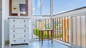 Ein Balkon mit einem weißen Schminktisch, einem Spiegel und einem Tisch.