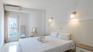 Una camera d'albergo con un letto grande, comodini, uno specchio e vista sull'esterno.